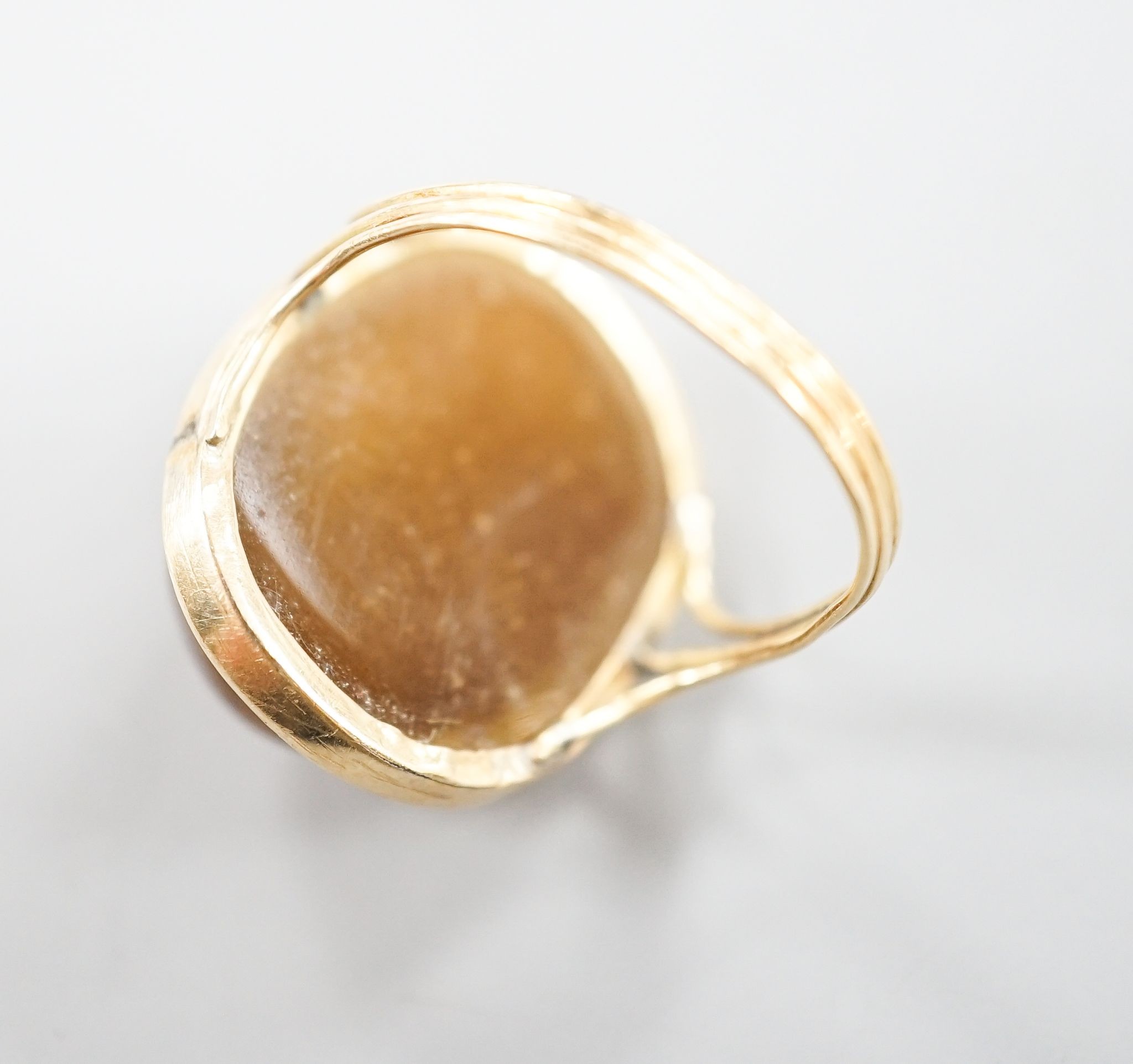 A yellow metal and cabochon brown chalcedony, carved with the face of a gentleman, size K, gross weight 7.3 grams.